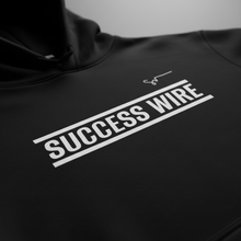 Load image into Gallery viewer, Close up SUCCESS WIRE Black hoodie with 'SUCCESS WIRE' Logo on a plain background