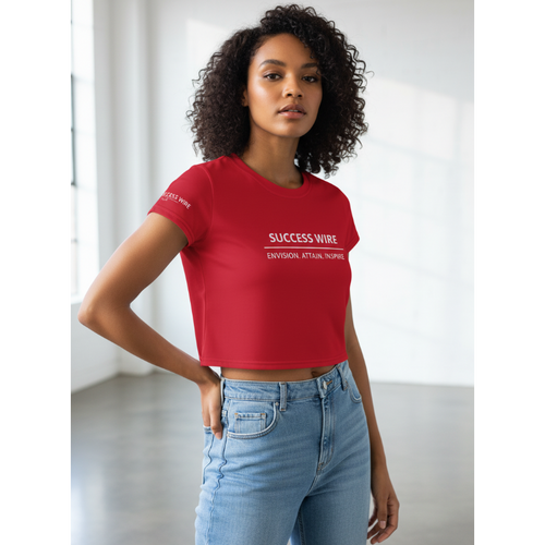 Woman wearing a red SUCCESS WIRE crop t-shirt with brand name and three pillars text and light blue jeans in a minimalistic setting