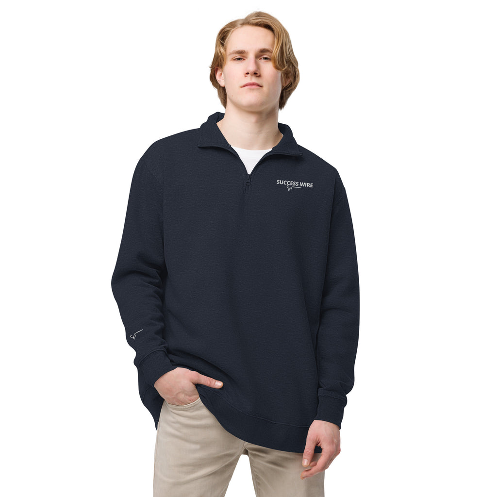 Man wearing a navy blue quarter zip pullover with SUCCESS WIRE logo on a white background